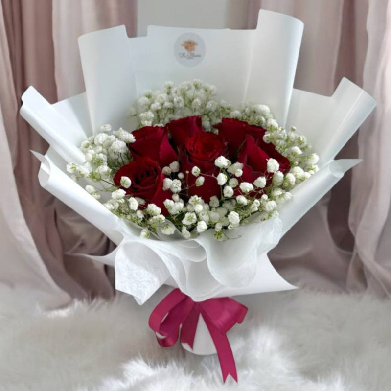 Red roses in a bouquet with baby’s breath