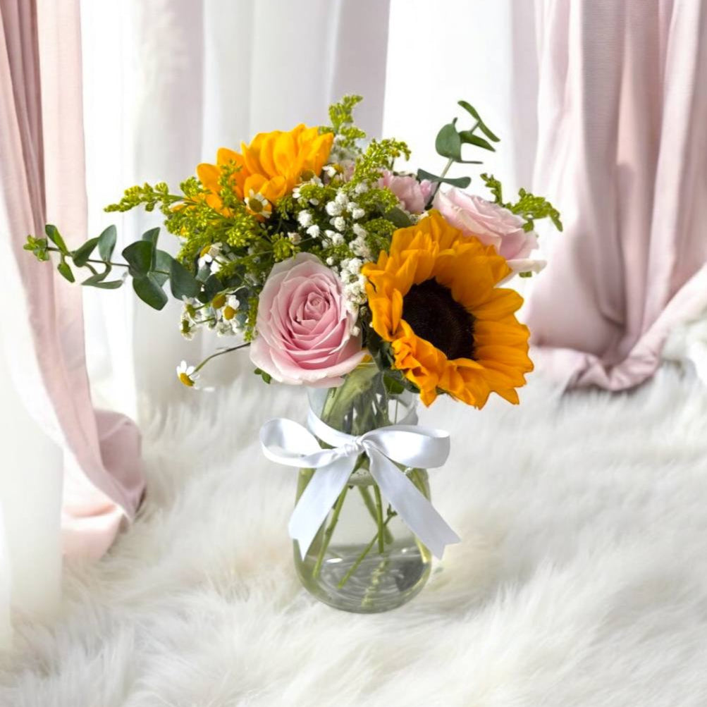 Sunflower and pink roses in a glass vase